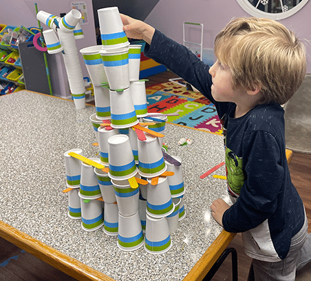 Building a paper cup and popsicle stick tower in stem club weekly classes at Clairmont Advanced Education Center.